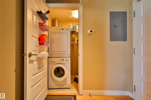 Laundry room with electric panel and stacked washing machine and dryer - 203 9908 84 Avenue, Edmonton, AB - Indoor Photo Showing Laundry Room