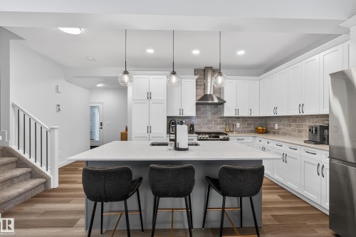 Kitchen with hanging light fixtures, an island with sink, stainless steel appliances, white cabinetry, and recessed lighting - 2098 Graydon Hill Crescent, Edmonton, AB - Indoor Photo Showing Kitchen With Upgraded Kitchen