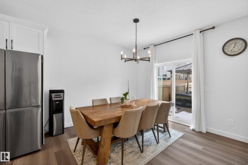 Dining space featuring a textured ceiling, dark wood-style floors, and a chandelier - 2098 Graydon Hill Crescent, Edmonton, AB - Indoor Photo Showing Dining Room