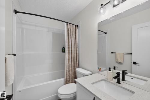 Full bath featuring shower / bathtub combination with curtain, a textured ceiling, and vanity - 2098 Graydon Hill Crescent, Edmonton, AB - Indoor Photo Showing Bathroom