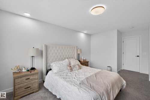 Carpeted bedroom featuring baseboards and a textured ceiling - 2098 Graydon Hill Crescent, Edmonton, AB - Indoor Photo Showing Bedroom