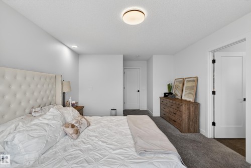 Carpeted bedroom featuring baseboards and a textured ceiling - 2098 Graydon Hill Crescent, Edmonton, AB - Indoor Photo Showing Bedroom