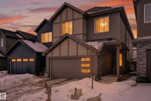View of front of house with board and batten siding, driveway, a shingled roof, a garage, and stone siding - 2098 Graydon Hill Crescent, Edmonton, AB - Outdoor