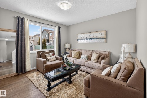 Living room featuring wood-type flooring and a textured ceiling - 5910 Anthony Crescent, Edmonton, AB - Indoor Photo Showing Living Room