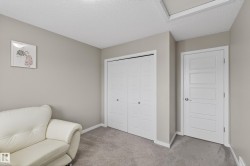 Living area with a textured ceiling and carpet flooring - 