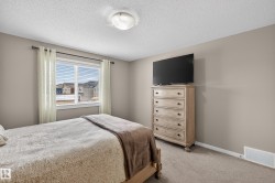 Carpeted bedroom featuring a textured ceiling and baseboards - 