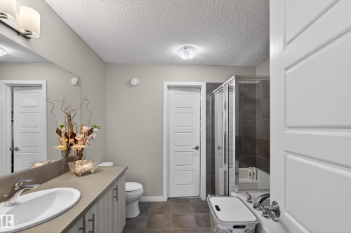 Full bathroom with vanity, a shower stall, a textured ceiling, and dark tile patterned flooring - 5910 Anthony Crescent, Edmonton, AB - Indoor Photo Showing Bathroom