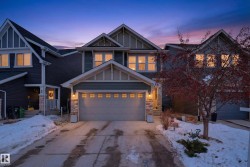Craftsman inspired home featuring board and batten siding, stone siding, and driveway - 