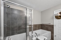Bathroom featuring a garden tub, a textured ceiling, a shower stall, and tile walls - 