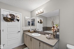 Bathroom featuring vanity, a textured ceiling, and dark tile patterned flooring - 