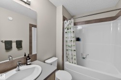 Full bath featuring vanity, shower / bathtub combination with curtain, and a textured ceiling - 