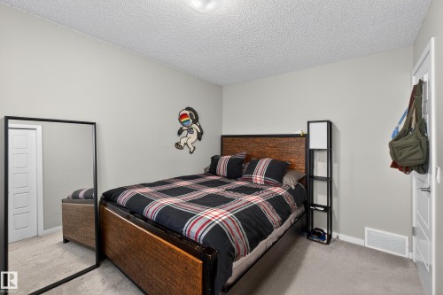 Bedroom with light carpet and a textured ceiling - 5910 Anthony Crescent, Edmonton, AB - Indoor Photo Showing Bedroom