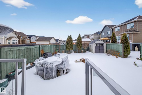 Yard covered in snow with a shed, a residential view, a fenced backyard, and a wooden deck - 5910 Anthony Crescent, Edmonton, AB - Outdoor With Deck Patio Veranda