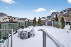 Yard covered in snow with a shed, a residential view, a fenced backyard, and a wooden deck - 