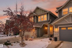 Craftsman-style home with stone siding, concrete driveway, and an attached garage - 