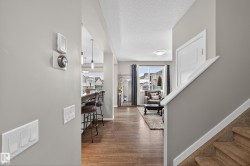 Foyer entrance with light wood-style flooring and a textured ceiling - 