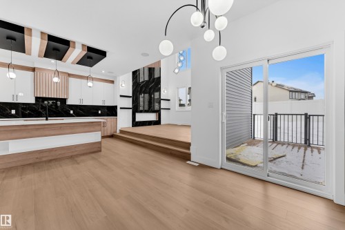 Kitchen featuring backsplash, decorative light fixtures, modern cabinets, light wood finished floors, and dual tone cabinetry - 733 Astoria Way, Devon, AB - Indoor Photo Showing Other Room
