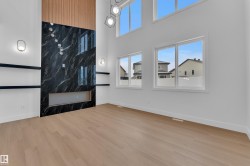 Unfurnished living room featuring a high ceiling and light wood-type flooring - 