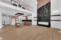 Unfurnished living room featuring light wood-type flooring and a high ceiling - 