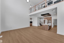 Unfurnished living room with a chandelier, a high ceiling, and light wood-style flooring - 