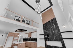 Kitchen featuring a kitchen island with sink, decorative light fixtures, light stone counters, light wood-style flooring, and a breakfast bar area - 