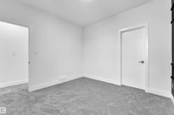 Unfurnished room featuring light carpet and baseboards - 