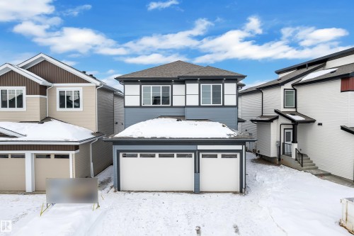View of front of house featuring an attached garage and a shingled roof - 733 Astoria Way, Devon, AB - Outdoor