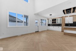 Unfurnished living room with parquet floors, plenty of natural light, and a high ceiling - 