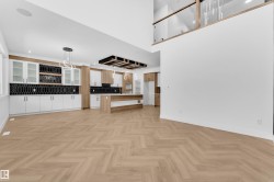 Kitchen with glass fronted cabinets, open floor plan, a breakfast bar area, parquet floors, and light countertops - 