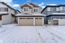 View of front of property featuring a garage and board and batten siding - 737 Astoria Way, Devon, AB  - Outdoor With Facade 