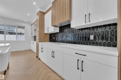 Dual tone kitchen with parquet flooring, recessed lighting, tasteful backsplash, two tone color scheme, and light stone counters - 