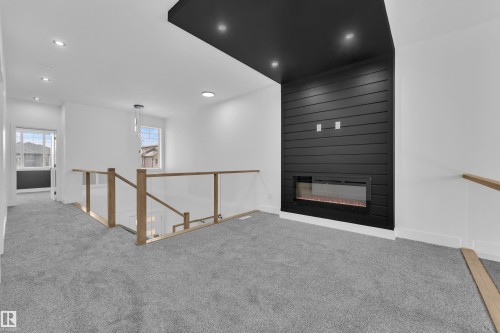 Carpeted spare room with recessed lighting and a large fireplace - 737 Astoria Way, Devon, AB - Indoor With Fireplace