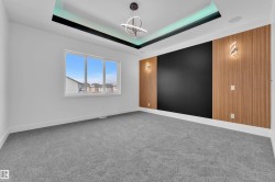 Unfurnished room with carpet flooring and suspended lighting - 