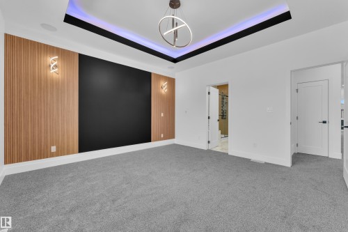 Empty room with carpet floors, a chandelier, and a raised ceiling - 737 Astoria Way, Devon, AB - Indoor Photo Showing Other Room