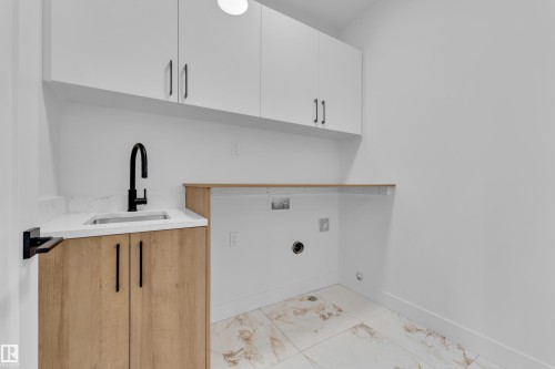 Laundry room with cabinet space, light marble finish flooring, and hookup for a washing machine - 737 Astoria Way, Devon, AB - Indoor