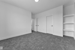 Unfurnished bedroom with dark carpet and baseboards - 