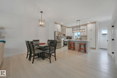 Dining space with suspended lighting and light wood finished floors - 21 Sienna Boulevard, Fort Saskatchewan, AB - Indoor Photo Showing Dining Room