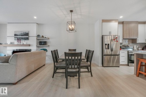 Dining area with a chandelier and light wood-style flooring - 21 Sienna Boulevard, Fort Saskatchewan, AB - Indoor