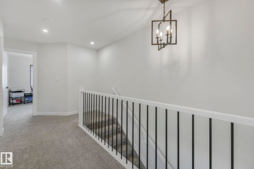 Hall with light colored carpet, an upstairs landing, and suspended lighting - 21 Sienna Boulevard, Fort Saskatchewan, AB - Indoor Photo Showing Other Room