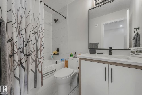Full bath featuring shower / bath combo with shower curtain, vanity, and a textured ceiling - 21 Sienna Boulevard, Fort Saskatchewan, AB - Indoor Photo Showing Bathroom
