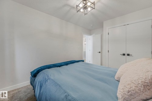Bedroom with a textured ceiling, carpet flooring, and a closet - 21 Sienna Boulevard, Fort Saskatchewan, AB - Indoor Photo Showing Bedroom