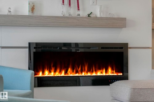 Detailed view of a lit fireplace - 21 Sienna Boulevard, Fort Saskatchewan, AB - Indoor Photo Showing Other Room With Fireplace