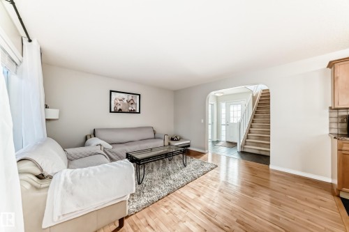 Living area featuring arched walkways and light wood finished floors - 5814 165 Avenue, Edmonton, AB - Indoor Photo Showing Living Room