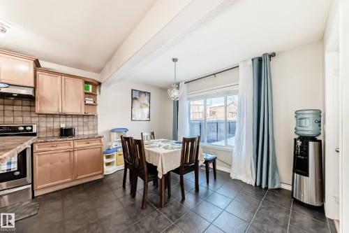 Dining room with dark tile patterned flooring and a chandelier - 5814 165 Avenue, Edmonton, AB - Indoor