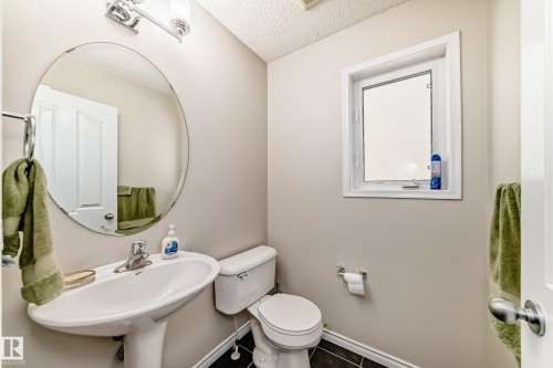 Half bathroom featuring a textured ceiling and dark tile patterned flooring - 5814 165 Avenue, Edmonton, AB - Indoor Photo Showing Bathroom