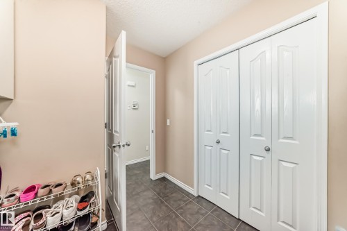 Hall featuring a textured ceiling and dark tile patterned flooring - 5814 165 Avenue, Edmonton, AB - Indoor Photo Showing Other Room