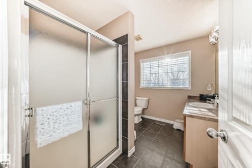 Full bath featuring a stall shower, vanity, and dark tile patterned floors - 5814 165 Avenue, Edmonton, AB - Indoor Photo Showing Bathroom