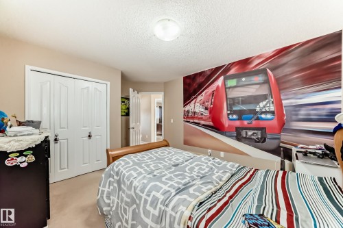 Bedroom with light colored carpet, a closet, and a textured ceiling - 5814 165 Avenue, Edmonton, AB - Indoor Photo Showing Bedroom