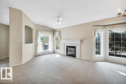 Unfurnished living room with carpet floors, a tile fireplace, and ceiling fan - 112 Haddow Close, Edmonton, AB - Indoor With Fireplace