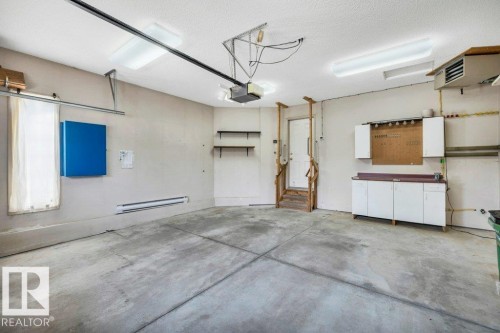 Garage with a heating unit, baseboard heating, and a garage door opener - 112 Haddow Close, Edmonton, AB - Indoor Photo Showing Garage